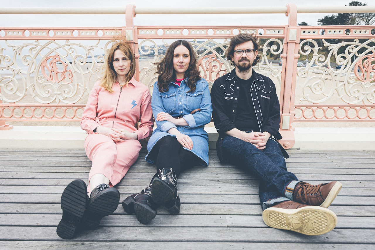 Jaywalkers sitting on floor of a pier with railings in background